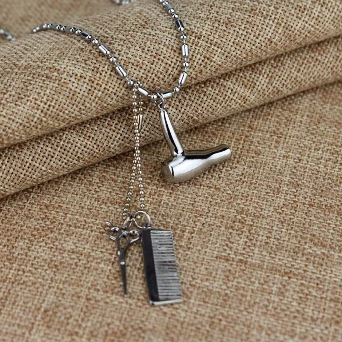 Frizēšanas šarms uz metāla ķēdītes – šķēres, ķemme, fēns